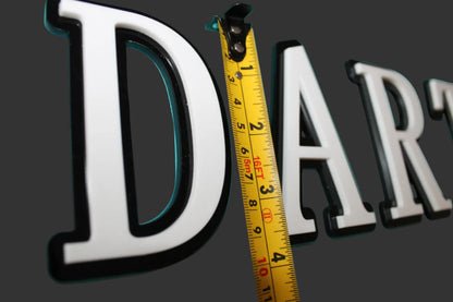 Tape measure leaning against the letter 'D' in a word on a teal background